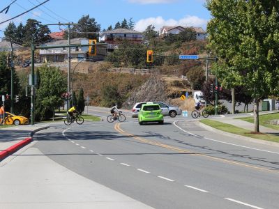 Image of people biking and driving along Watkiss Way and Burnside Road W